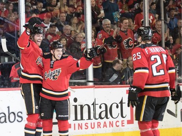 Dougie Hamilton celebrates after scoring a goal with Johnny Gaudreau and his brother Freddie Hamilton after at the Scotiabank Saddledome in Calgary, Ab, on Saturday, March 26, 2016. Freddie Hamilton assisted the goal for his brother.