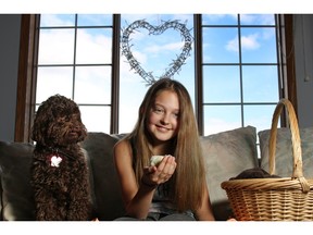 Natasha Gould, 12, sits with dog Ryder as she plays with some baby chicks she has been caring for in her Calgary home on Tuesday March 8, 2016. Natasha had her dream of being a cheerleader cut short by a terminal brain cancer diagnosis last year. But now the team who she was trying out for is including her in a cheerleading show.