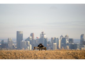 Ashley Pierce, left and Sandeep Chopped enjoy the Calgary skyline view from Nose Hill Park in Calgary, AB., on Friday, March 25, 2016.