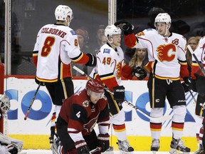 Calgary Flames' Hunter Shinkaruk (49) celebrates Sean Monahan's second-period goal with Joe Colborne against the Arizona Coyotes on Monday. Shinkaruk was making his debut with the Flames.