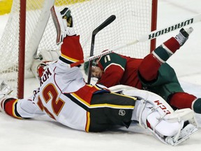Minnesota Wild's Zach Parise, right, slides into the net in a collision with former teammate, Calgary Flames goalie Niklas Backstrom of Finland in the third period Thursday in St. Paul, Minn. Parise scored three first period goals for the hat-trick as the Wild won 6-2.
