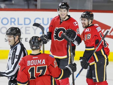 Joe Colborne of the Calgary Flames celebrates his empty-net first-period goal on the St. Louis Blues with teammates Lance Bouma and Josh Jooris in Calgary, Alta., on Monday, March 14, 2016. Lyle Aspinall/Postmedia Network