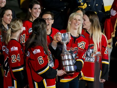 Members of the Calgary Inferno bring their championship hardware onto the ice before NHL action between the Calgary Flames and Winnipeg Jets on Wednesday.