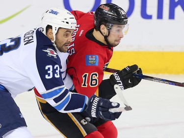Winnipeg Jets Dustin Byfuglien battles against Josh Jooris of the Calgary Flames during NHL hockey in Calgary, Alta., on Wednesday, March 16, 2016.