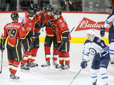 Deryk Engelland, Josh Jooris, Mark Giordano, Sean Monahan and Johnny Gaudreau of the Calgary Flames celebrate their third unanswered goal in the first period against the Winnipeg Jets in Calgary, Alta., on Wednesday, March 16, 2016. The Flames won 4-1. Lyle Aspinall/Postmedia Network