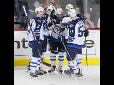The Winnipeg Jets celebrate their second-period goal on the Calgary Flames in Calgary, Alta., on Wednesday, March 16, 2016. The Flames won 4-1. Lyle Aspinall/Postmedia Network