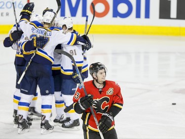 Sean Monahan of the Calgary Flames skates by the St. Louis Blues as they celebrate a goal in Calgary, Alta., on Monday, March 14, 2016. The Flames won 7-4. Lyle Aspinall/Postmedia Network