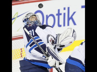 Winnipeg Jets goalie Ondrej Pavelec catches a puck against the Calgary Flames in Calgary, Alta., on Wednesday, March 16, 2016. The Flames won 4-1. Lyle Aspinall/Postmedia Network