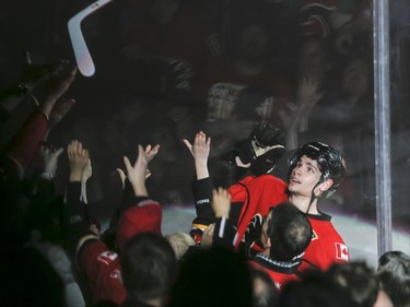 Sean Monahan of the Calgary Flames tosses his stick to fans after being named the game's first star against the St. Louis Blues in Calgary, Alta., on Monday, March 14, 2016. The Flames won 7-4. Lyle Aspinall/Postmedia Network