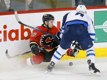 Josh Jooris of the Calgary Flames crashes near Andrew Copp of the Winnipeg Jets in Calgary, Alta., on Wednesday, March 16, 2016. The Flames won 4-1. Lyle Aspinall/Postmedia Network