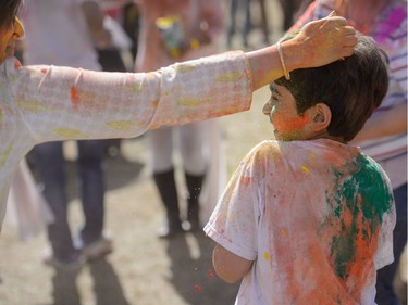 A child, right, gets colour rubbed on him while celebrating the festival of Holi at Lloyd Park in Calgary, AB., on Saturday, March 26, 2016. Holi, also known as the festival of colours, is a spiritual Hindu festival that marks the arrival of spring.
