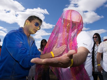Gaurav Jain, left dances with Grummet Sing while celebrating the festival of Holi at Lloyd Park in Calgary, AB., on Saturday, March 26, 2016. Holi, also known as the festival of colours, is a spiritual Hindu festival that marks the arrival of spring.