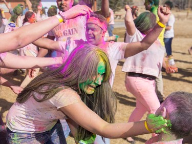 Jagat Kaur, foreground, rubs green colour onto a child while celebrating the festival of Holi at Lloyd Park in Calgary, AB., on Saturday, March 26, 2016. Holi, also known as the festival of colours, is a spiritual Hindu festival that marks the arrival of spring.