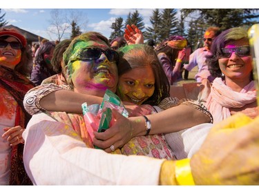Manish Chopra, left foreground, and Vivau Khosla, right foreground, pose for a selfie while celebrating the festival of Holi at Lloyd Park in Calgary, AB., on Saturday, March 26, 2016. Holi, also known as the festival of colours, is a spiritual Hindu festival that marks the arrival of spring.