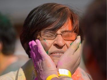 Ritu Chandra gets colour rubbed on her face while celebrating the festival of Holi at Lloyd Park in Calgary, AB., on Saturday, March 26, 2016. Holi, also known as the festival of colours, is a spiritual Hindu festival that marks the arrival of spring.
