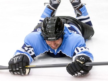 Tenor and guitarist Remigio Pereira falls while trying to pull a requested sliding air guitar before a Juno Cup practice game at Max Bell Centre in Calgary, Alta., on Thursday, March 31, 2016. Musicians and former NHLers were prepping for the Juno Cup hockey game set for this Friday, part of events leading up to the Juno Awards on Sunday at the Saddledome. Lyle Aspinall/Postmedia Network