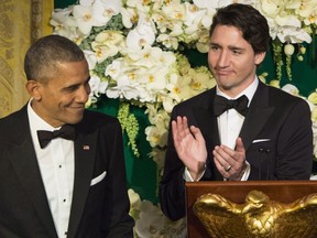 Prime Minister Justin Trudeau applauds U.S. President Barack Obama during a state dinner in Washington, D.C.