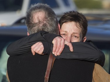 People embrace after a house fire that ripped through four homes on Kincora Drive N.W. on Tuesday.