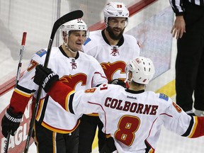 Calgary Flames' Lance Bouma (17) celebrates his goal with teammates Deryk Engelland (29) and Joe Colborne (8) during the third period of an NHL hockey game against the Pittsburgh Penguins in Pittsburgh.