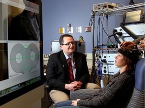 Dr. Frank MacMaster, left, uses transcranial magnetic stimulation on a test patient at the Alberta Children's Hospital in 2012. He says the treatment has helped a number of patients.