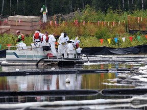 Canadian Natural Resources workers clean up bitumen emulsion in a marsh near Cold Lake in 2013. Results of an investigation into the incident are to be unveiled Monday.