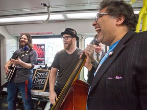 Calgary Mayor Naheed Nenshi takes a photo with Steel and Timber band members Nathan H-Thompson, left, and Phil Brayton while riding the CTrain on Monday, March 28, 2016. The band is one of ten Calgary acts that will be playing on the trains during Juno week.