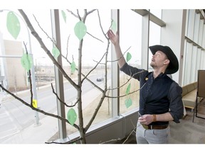 Country music star Paul Brandt hangs a 'W: at MRU' pledge on a tree at Mount Royal University on Monday. Brandt is part of the campaign at the university to help raise awareness of missing and murdered indigenous women; he's also taking on a two-year volunteer position at the university as the Storyteller-in-Residence.