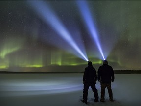 Photographers Jeremy Mac Knott and Stan Novotny viewing the northern lights with headlamps.