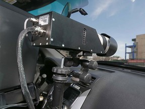 A Calgary Police Service peace officer operates a photo radar camera on 9 Ave SE in Inglewood in a playground zone on Sunday, March 27, 2016.