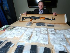 Staff Sgt. Keith Hurley poses with an AK-47 assault rifle that was seized during a drug investigation in northwest Calgary along with $57,000 worth of cocaine, methamphetamine and heroin during a media availability in Calgary, Ab., on Wednesday March 30, 2016.