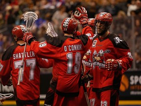 Calgary Roughnecks Reilly O'Connor high fives teammate Curtis Dickson (17), who scored the 11th goal for his team in the fourth quarter during the National Lacrosse League action at the ACC in Toronto on Friday, March 11, 2016.