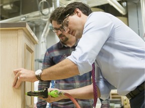 Prime Minister Justin Trudeau assists carpentry student Mitch Beaudet with a project at SAIT Polytechnic on Tuesday. Reader says it's time the PM got to work improving Canada’s economy and unemployment rate.