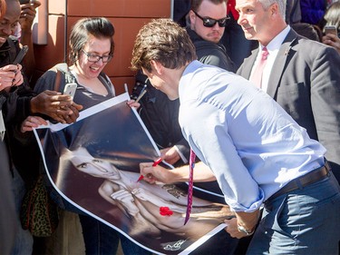 Justin Trudeau signs Kelly Archibald's poster of him at SAIT Polytechnic in Calgary, Ab, on Tuesday, March 29, 2016. Trudeau visited a fourth-year carpentry class and greeted students.