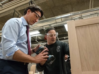 Chris Wenaus passes Justin Trudeau a drill during a visit at SAIT Polytechnic in Calgary, Ab, on Tuesday, March 29, 2016. Trudeau stopped by a fourth-year carpentry class and greeted students.