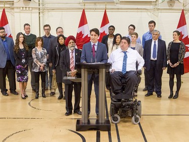 Prime Minister Justin Trudeau is flanked by MPs Darshan Kang and Kent Hehr, and a bevy of roundtable participants, after a roundtable discussion at the Kerby Centre in Calgary, Alta., on Tuesday, March 29, 2016. Trudeau was part of a roundtable discussion on employment insurance at the Kerby Centre before touring a carpentry lab at SAIT Polytechnic.