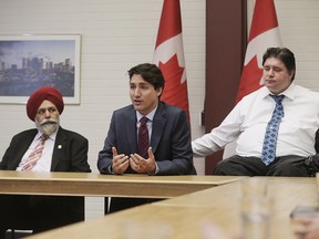 Prime Minister Justin Trudeau, centre, flanked by Calgary MPs Darshan Kang, left, and Kent Hehr.