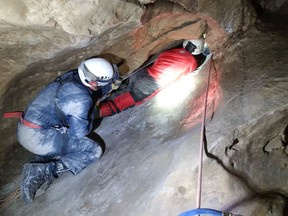 Emergency officials work to rescue a man from the Laundry Chute in Rat's Nest Cave near Canmore.