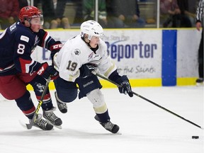 The Spruce Grove Saints' Brandon Biro (19) battles the Brooks Bandits' Cale Makar (8) during first period AJHL action at Grant Fuhr Arena, in Spruce Grove Alta. on Saturday April 16, 2016. This was game 2 of the 2016 Alberta Junior Hockey League Gas Drive Cup. Photo by David Bloom