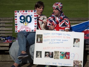 Londoners hold placards wishing the Queen a happy 90th birthday on Wednesday. The Queen's birthday is Thursday.