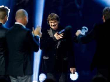 Burton Cummings walks toward Nickelback to accept his hall of fame honour during the Juno Awards at the Scotiabank Saddledome in Calgary, Alta., on Sunday, April 3, 2016. The Juno Awards celebrate the best in Canadian music. (Lyle Aspinall/Postmedia Network)