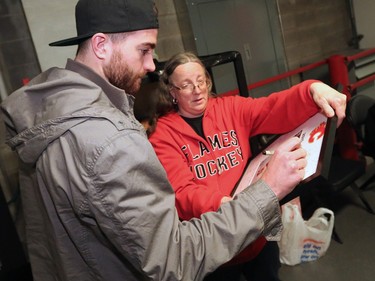 The Calgary Flames' TJ Brodie signs an autograph for Jeannette Wilson before heading out of the Scotiabank Saddledome as the team cleared out their lockers for the season on Monday, April 11, 2016.