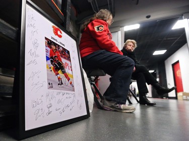 Jeannette Wilson, left chats with security guard Doris Martin as she waits to get all the 2015-2016 Calgary Flames to sign a poster at the Scotiabank Saddledome on Monday, April 11, 2016. The team cleaned out their lockers until next season.