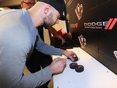 Calgary Flames captain Mark Giordano signs pucks at the Scotiabank Saddledome as the team cleared out their lockers for the season on Monday, April 11, 2016.