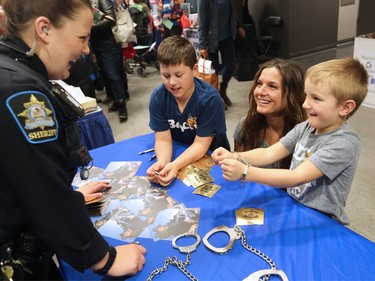 Gabe Stan, 6 tries out some handcuffs with brother, Josh, 9 and mom Elena at the Alberta Sheriffs display at the Calgary Courts Centre on Law Day 2016 - Saturday, April 16, 2016.