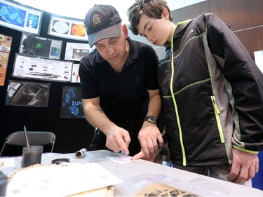 Calgary police Cst. Sean Cull demonstrates finger printing to Matthew Deere, 13, on Law Day at the Calgary Courts Centre - Saturday, April 16, 2016.