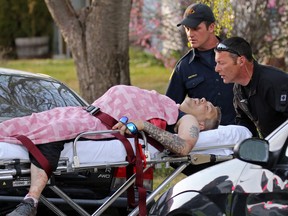 Calgary EMS move the victim of a stabbing from the alley behind Colgrove Avenue N.E. on Tuesday evening, April 19, 2016. 
GAVIN YOUNG/POSTMEDIA