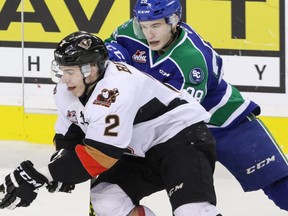 Calgary Hitmen Jake Bean is corralled by Swift Current Broncos Tyler Adams in WHL action at the Scotiabank Saddledome in Calgary, Alberta, on Saturday January 23, 2016. Mike Drew/Postmedia Network