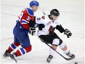 Calgary Hitmen Jake Bean, right and Edmonton Oil Kings Brett Pollock battle for the puck in WHL action at the Scotiabank Saddledome in Calgary, Alberta, on Saturday, March 12, 2016. Leah Hennel/Postmedia