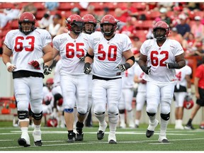 CALGARY, ; JUNE 7, 2015  --  Offensive linemen Pierre Lavertu, 63; Dan Federkeil, 65; Shane Bergman, 60' Spencer Wilson, 50 and Edwin Harrison, 62; head out onto the field as the Calgary Stampeders hosted their training camp annual intra-squad game on Sunday, June 7, 2015 at McMahon Stadium. (Lorraine Hjalte/Calgary Herald) For Sports story by . Trax # 00065933A