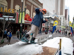Jonathan Hudson heads down the ramp during Sunshine Villages's rail jam on Stephen Avenue Mall in Calgary at lunch hour on Thursday, April 14, 2016. The ski resort trucked in some snow to help promote the great spring skiing open at Sunshine until May 23.
